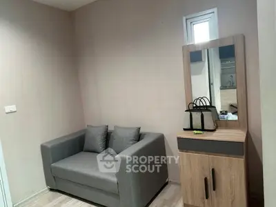 Cozy small living room with modern gray sofa and wooden cabinet, perfect for compact spaces.