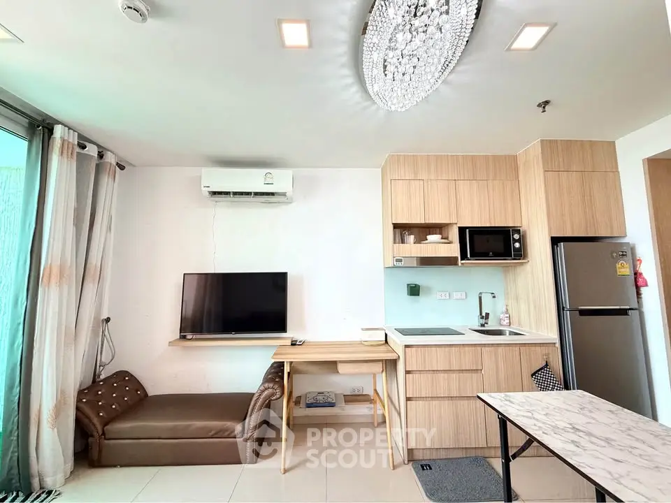 Modern living room with open kitchen, featuring sleek appliances and stylish decor.