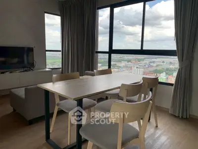 Modern living room with dining area and panoramic city view, featuring sleek furniture and large windows.