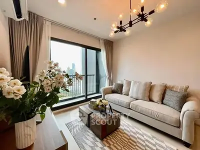 Elegant living room with plush seating, chic lighting, and a large window leading to a balcony with a city view, perfect for urban living.