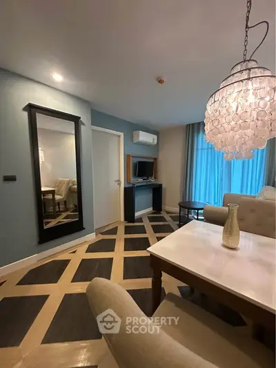 Stylish living room with elegant chandelier and modern decor in a contemporary apartment.