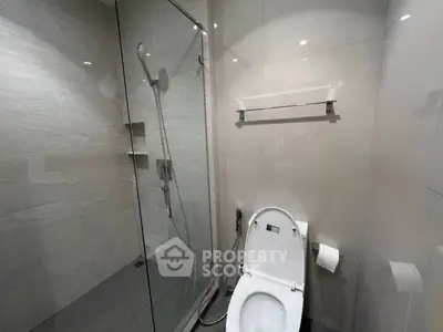 Modern bathroom with glass shower and sleek toilet design.