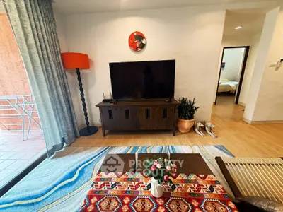 Charming living room with modern decor and vibrant accents, featuring a cozy seating area and stylish entertainment setup.
