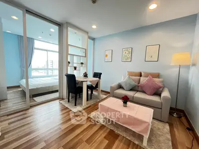 Modern living room with cozy sofa, dining area, and view into bedroom, featuring stylish decor and natural light.