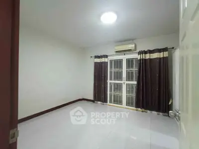 Spacious unfurnished room with air conditioning and large window, perfect for customization.