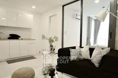 Modern living room with sleek black sofa and minimalist kitchen design