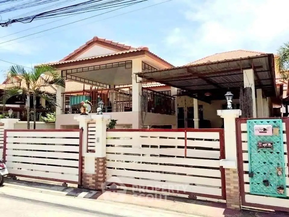 Charming suburban house with spacious driveway and gated entrance, ideal for family living.