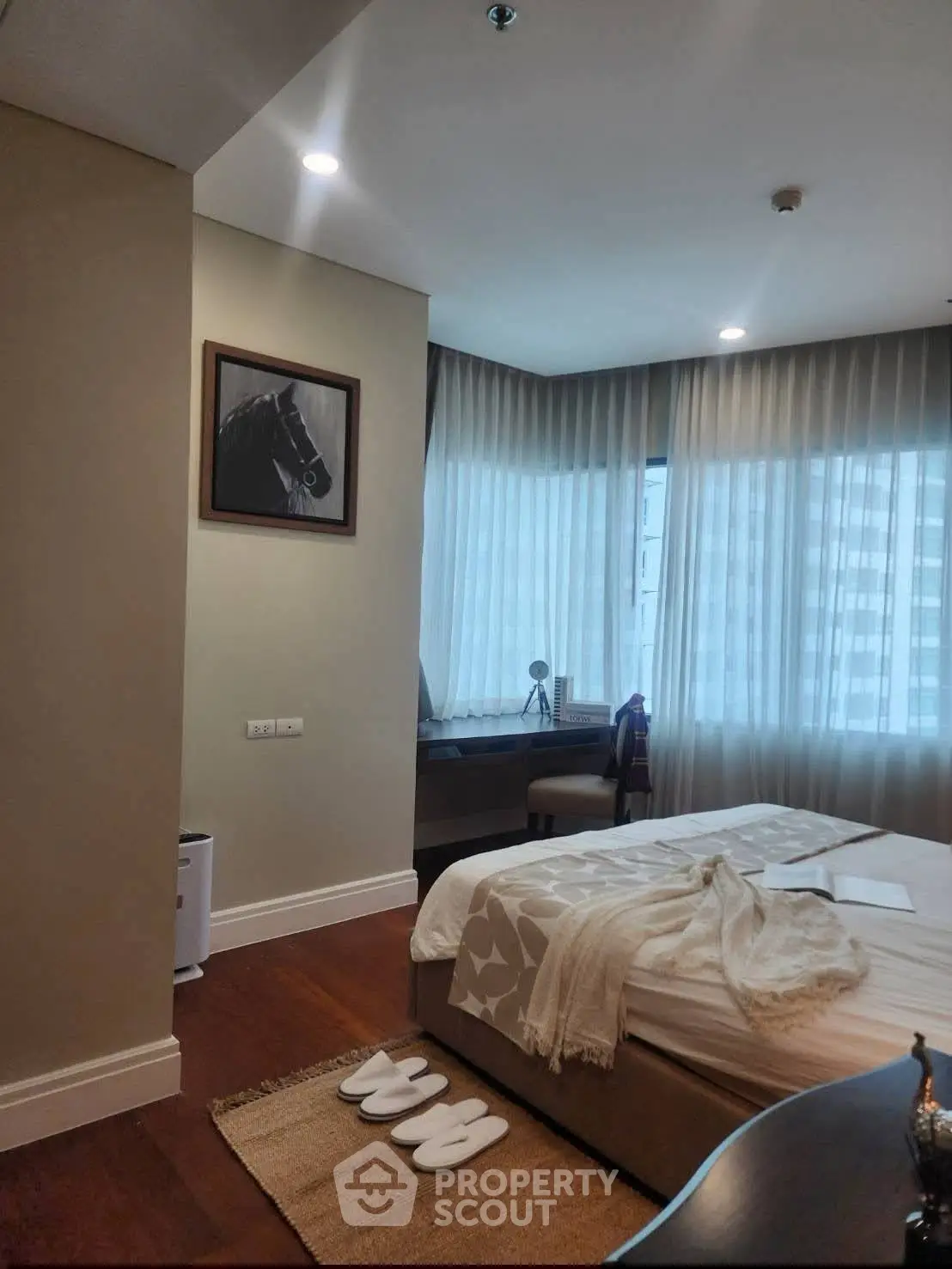 Luxurious bedroom with elegant decor and large windows offering natural light.