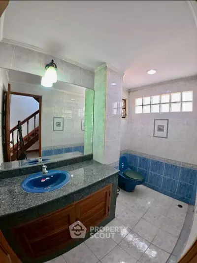 Spacious bathroom with blue fixtures and elegant tile design