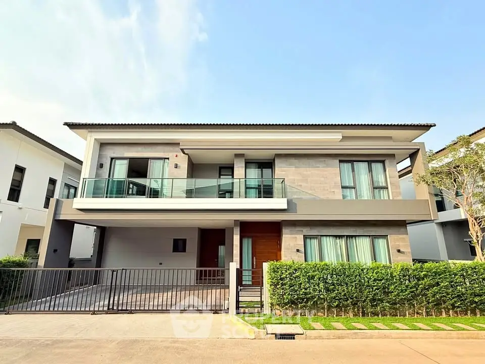Modern two-story house with large windows and balcony in a serene neighborhood.