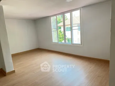 Spacious and well-lit empty room with large windows offering a serene tree-lined view, perfect canvas for personalized interior design.