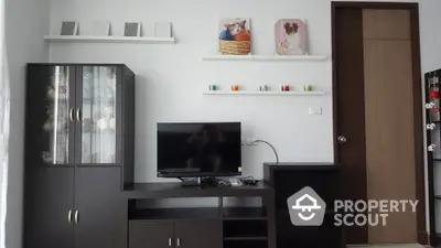 Modern living room with sleek dark furniture and wall-mounted shelves