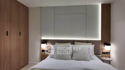 Modern bedroom with stylish lighting and wooden wardrobe, perfect for a cozy retreat.