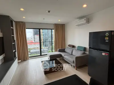 Modern living room with city view, featuring sleek furniture and large windows for natural light.