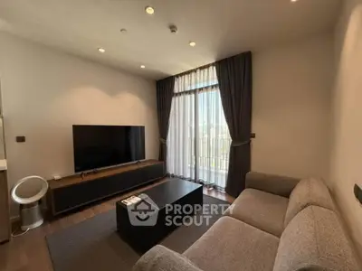 Modern living room with large TV, cozy sofa, and floor-to-ceiling windows with city view.