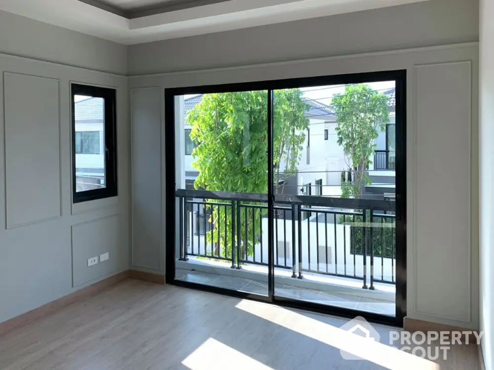 Spacious and well-lit bedroom with large windows leading to a private balcony overlooking a serene neighborhood, perfect for relaxation and comfort.