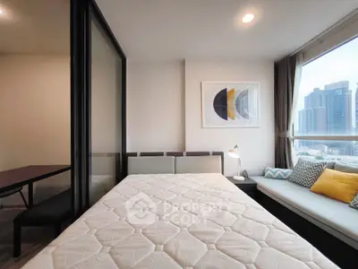 Modern bedroom with city view, stylish decor, and cozy seating area