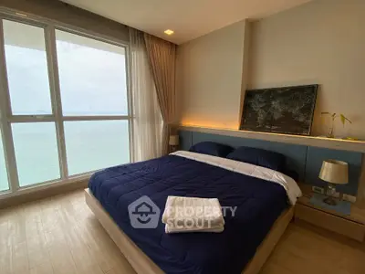 Luxurious bedroom with ocean view, featuring modern decor and large windows for natural light.