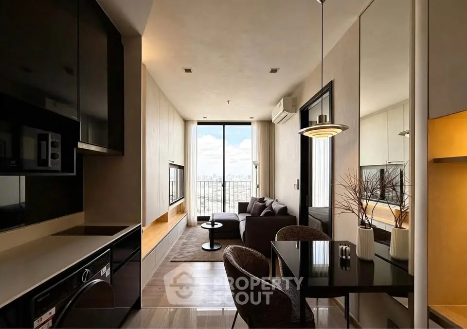 Modern living room with open kitchen, featuring sleek furniture and large window with city view.