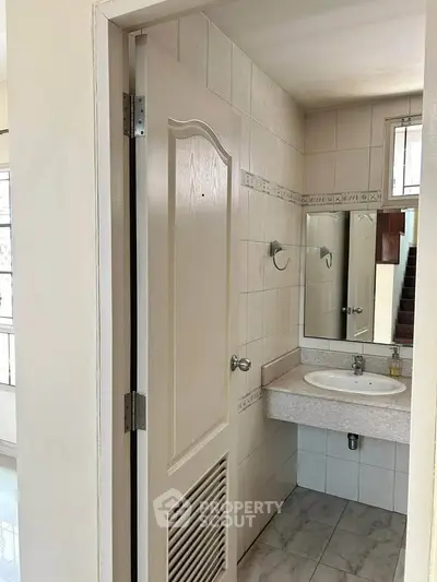 Compact bathroom with sink and mirror in a cozy home setting.
