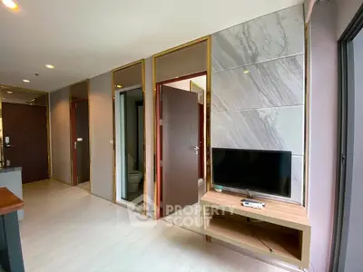 Modern apartment interior with TV and marble accents, showcasing sleek design and open layout.