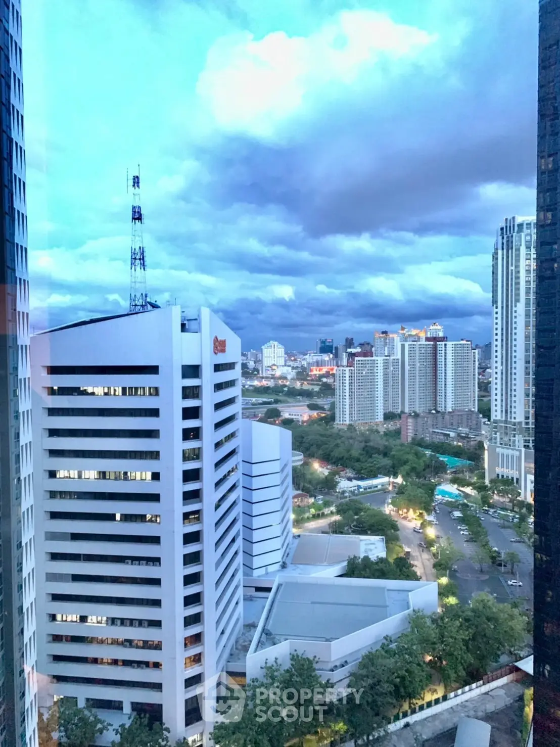 Stunning cityscape view from high-rise building with dramatic clouds and urban skyline.