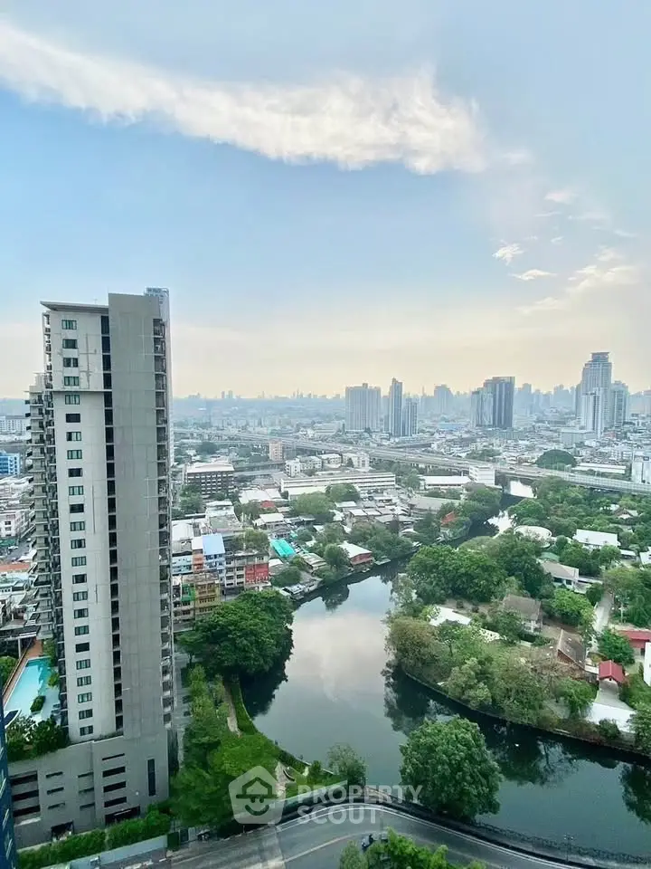 Stunning cityscape view from high-rise apartment overlooking river and skyline.