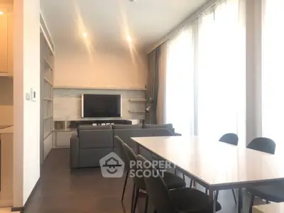 Spacious modern living room with large windows and elegant dining area.