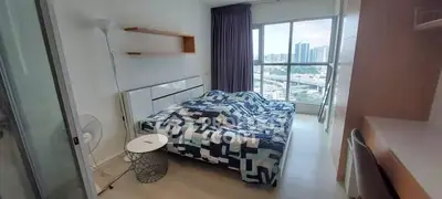 Modern bedroom with city view, featuring a cozy bed and stylish decor.
