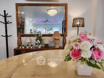 Elegant living room with chic decor, large mirror, and stylish lighting, perfect for modern living.