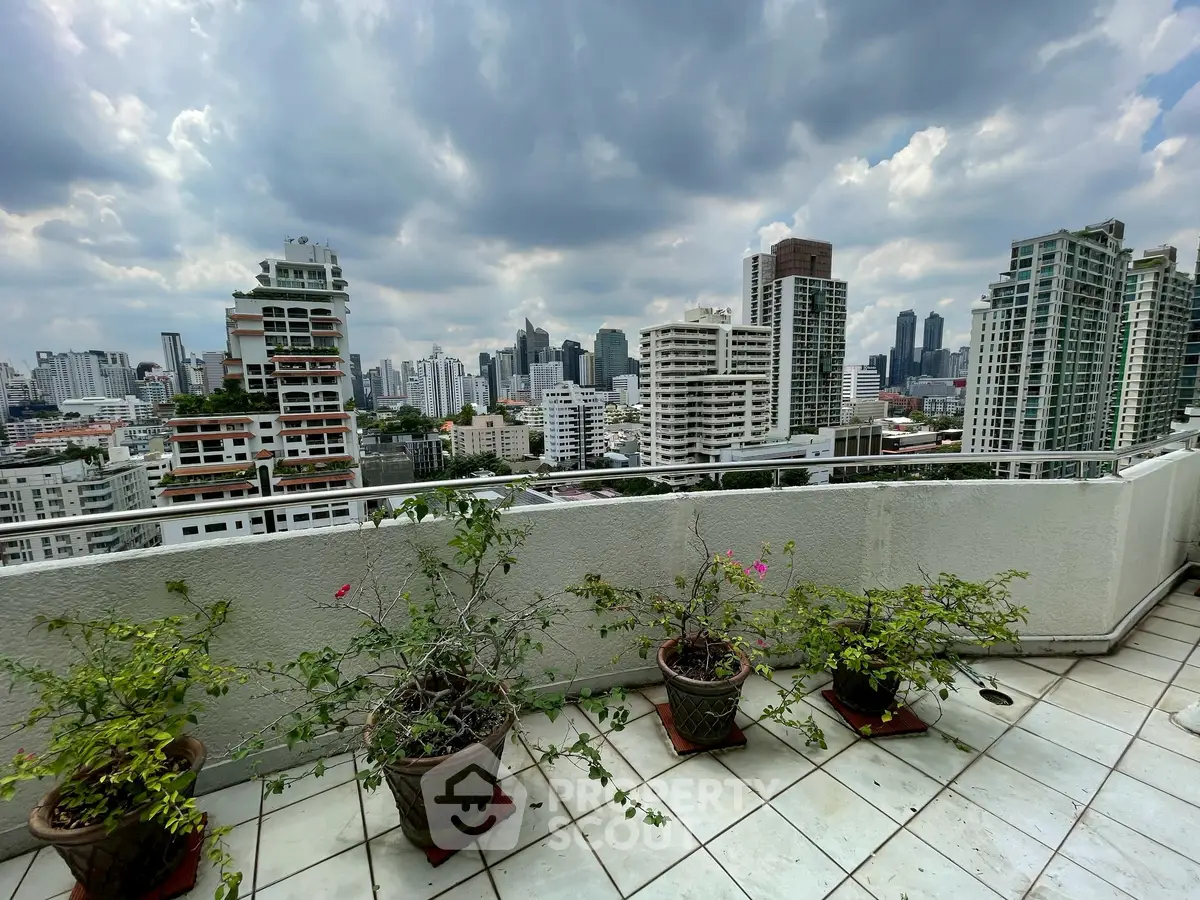 Stunning cityscape view from a spacious balcony with potted plants, perfect for urban living.