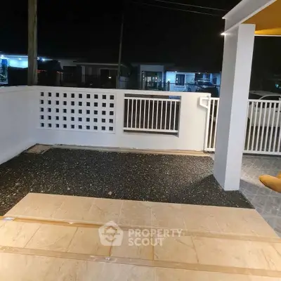 Spacious modern balcony with stylish railing and tiled flooring at night