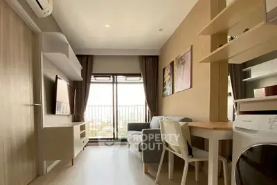 Modern living room with balcony view, stylish furniture, and natural light.
