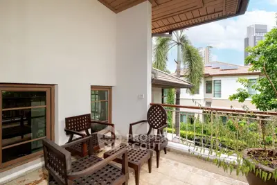 Charming balcony with wooden furniture and lush greenery, offering a serene outdoor retreat with city views.