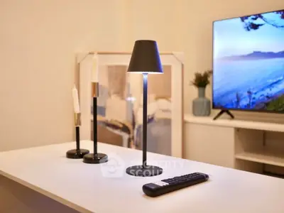 Modern living room with stylish decor and flat-screen TV, perfect for relaxation.