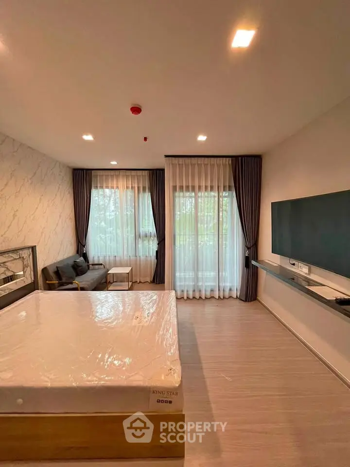 Spacious bedroom with modern decor, large windows, and elegant curtains in a stylish apartment.