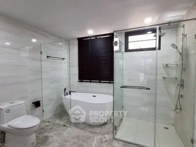 Luxurious modern bathroom with freestanding tub and glass shower enclosure