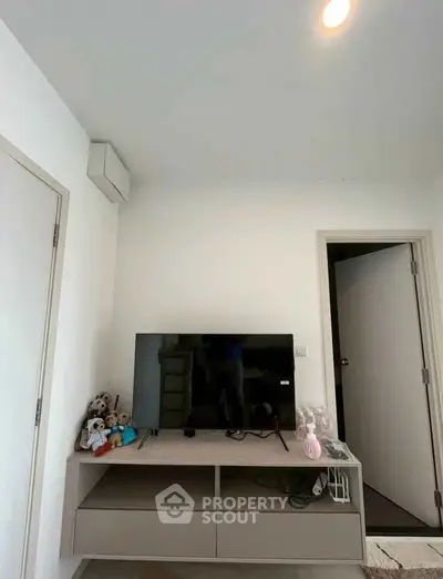 Modern living room with sleek TV stand and plush toys, perfect for cozy family gatherings.