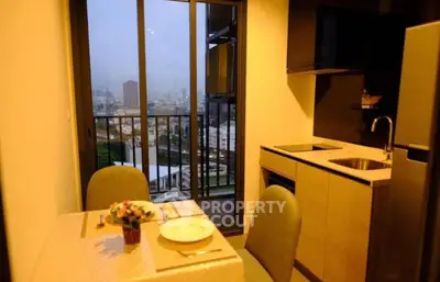 Modern kitchen with dining area and balcony view in urban apartment