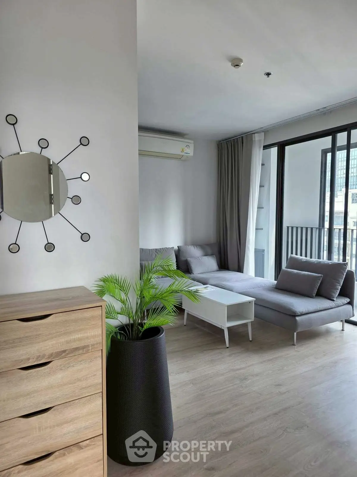 Modern living room with stylish decor and large windows offering natural light.