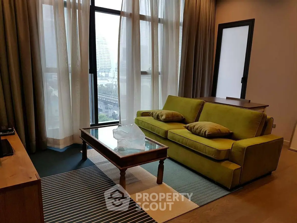 Stylish living room with green sofa and city view, perfect for modern urban living.