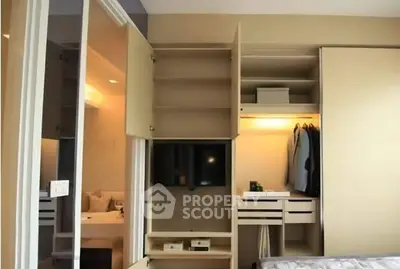 Modern bedroom with built-in wardrobe and TV, showcasing sleek design and ample storage space.