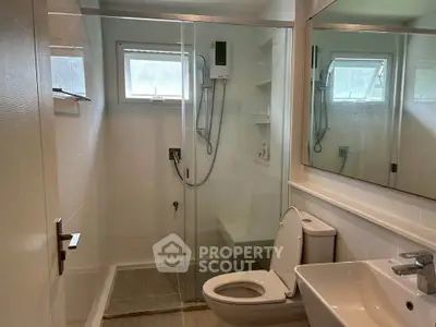 Modern bathroom with glass shower enclosure and sleek fixtures.
