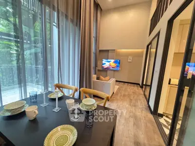 Modern living room with elegant dining area and large windows in a stylish apartment.