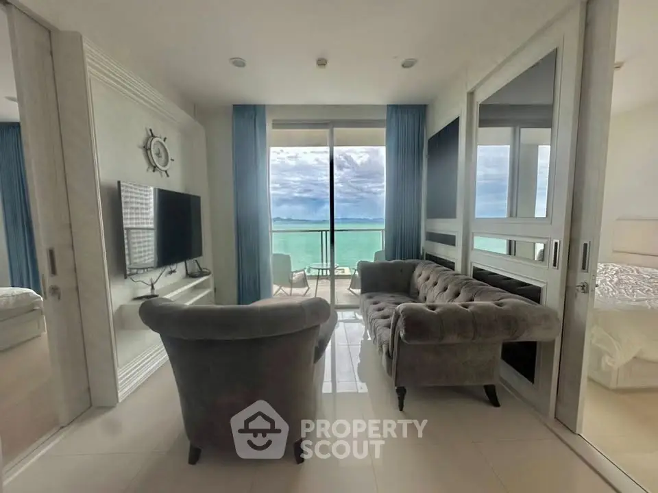 Luxurious living room with ocean view, elegant furniture, and large windows for natural light.