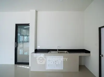 Modern minimalist kitchen with sleek countertops and ample natural light.