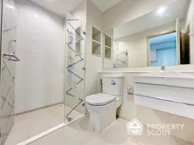 Modern bathroom with glass shower and sleek fixtures in a contemporary home.