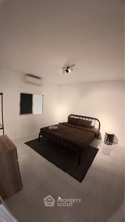 Spacious minimalist bedroom with modern metal bed frame and sleek decor