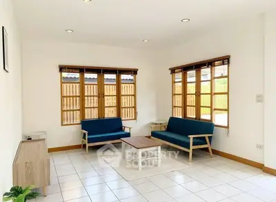 Bright living room with modern furniture and large windows for natural light.