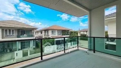 Spacious balcony with glass railing offering a stunning view of suburban homes under a clear blue sky.